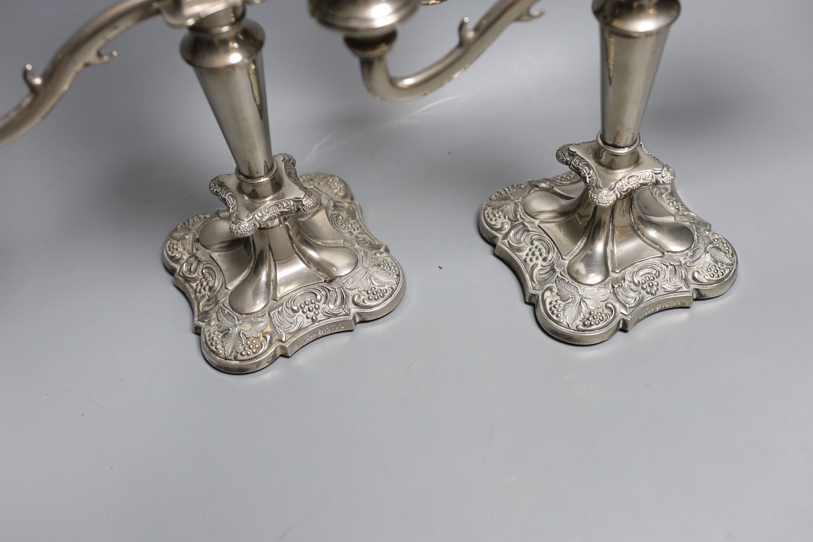 A pair of two branch, three light plated candelabra - 26cm high